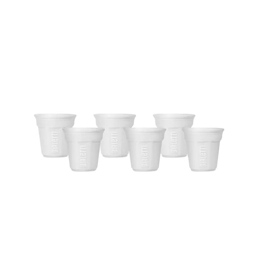 Set de 6 vasos de cerámica para espresso en blanco, dispuestos en fila.