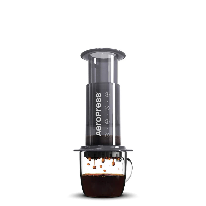 AeroPress de prensa de café con cilindro transparente y base oscura, asa lateral