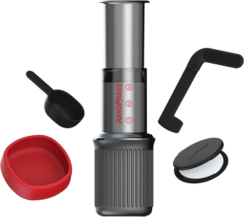 AeroPress GO con componentes: cilindro, base acanalada y tapas negra y roja