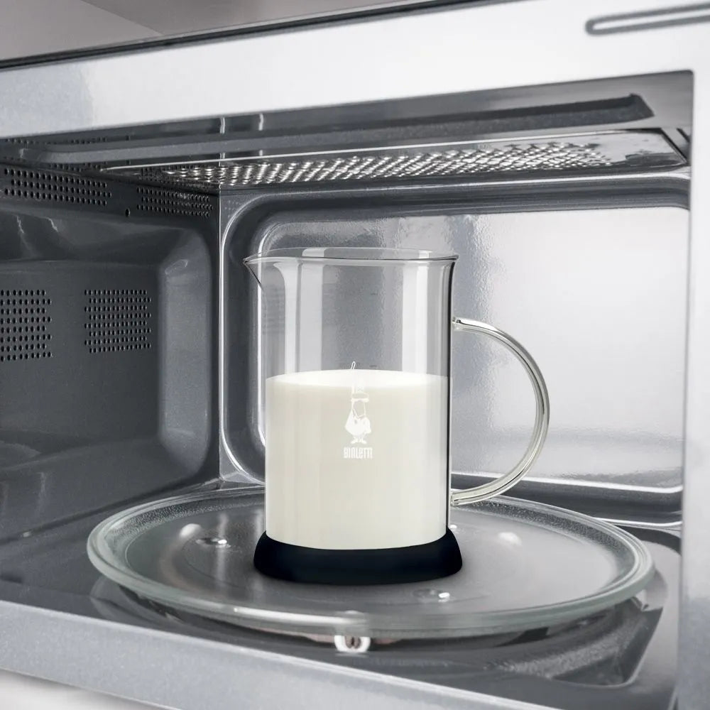 Espumador de leche Bialetti en horno, jarra de acero con espuma blanca.