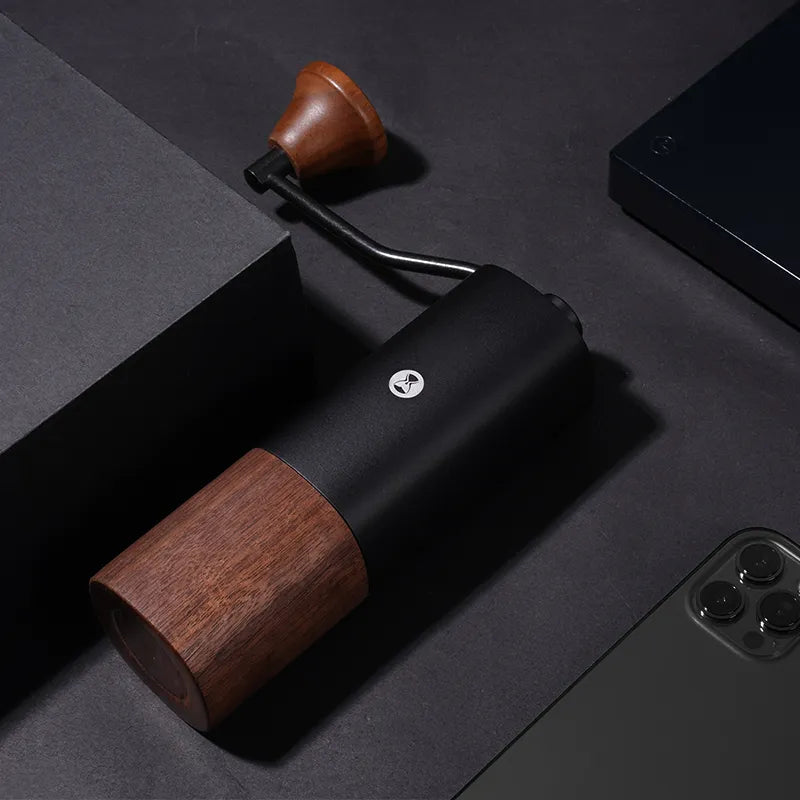 Molino de café negro con base de madera y manivela, vista superior