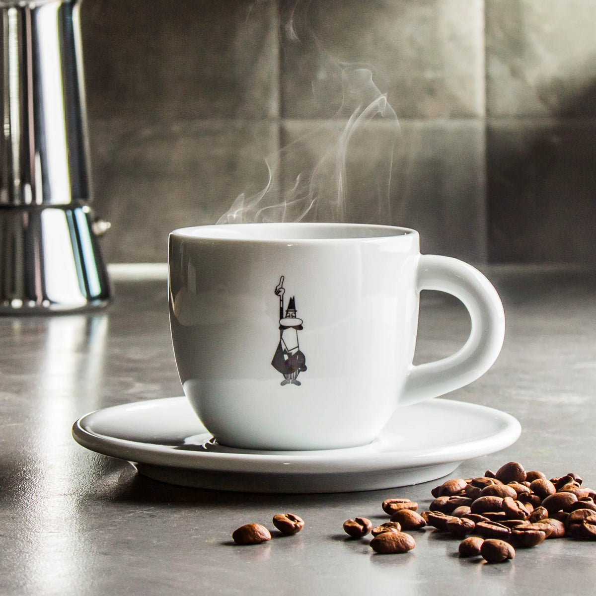 Taza de porcelana blanca y plato a juego con diseño Bialetti