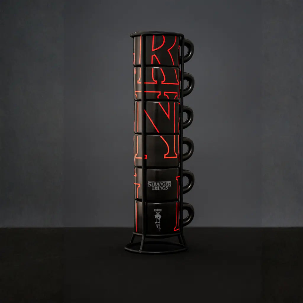 Torre de tazas apilables negras con gráficos rojos y asas, soporte metálico